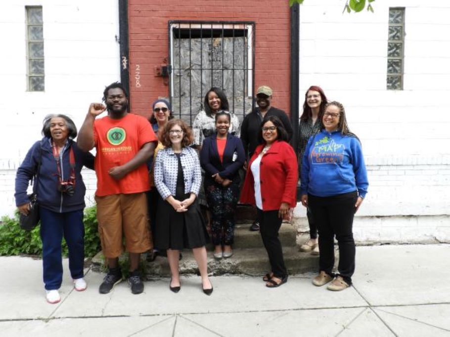 A group of people standing in front of a door that will become the African Heritage Co-Op in Buffalo, NY.
