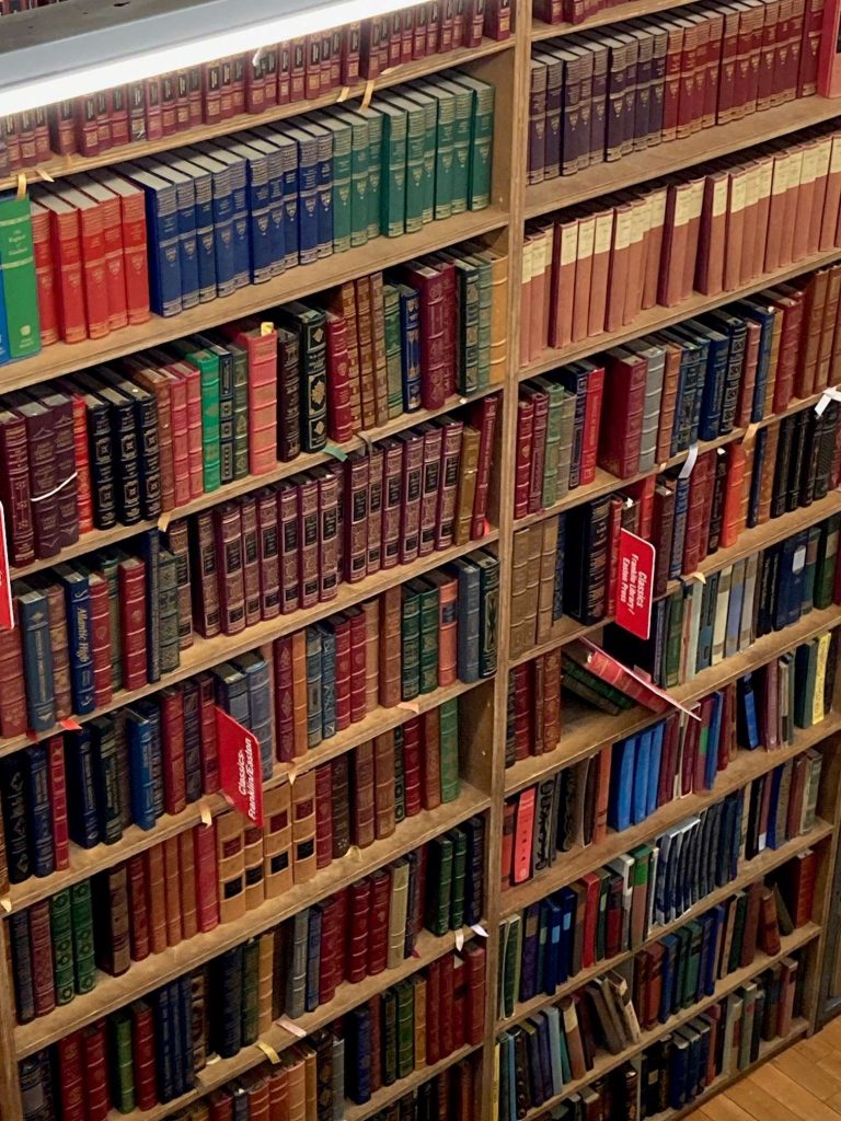 A large, tall bookcase filled with lots of books with colorful spines.